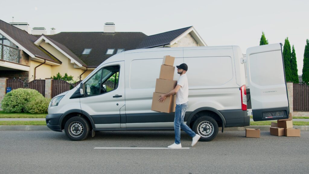 man delivering boxes from transit van